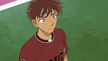 a boy in a red shirt with the letter a on it is praying