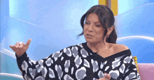 a woman in a leopard print sweater is sitting on a couch with her eyes closed .