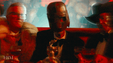 a man with a helmet on his head is sitting at a table with glasses of wine