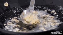 a spoon is being used to stir food in a pan of oil .