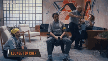 a group of people are sitting in a living room with a sign that says lounge top chef