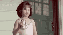 a little girl is holding a can of soda in her hand .