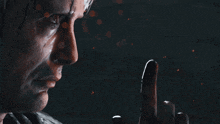 a close up of a man 's face with a finger pointing up