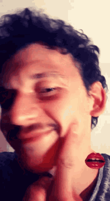 a close up of a man 's face with a red lip on it