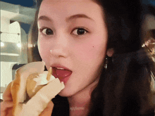 a close up of a woman eating an ice cream cone with the name njffaerie on the bottom right