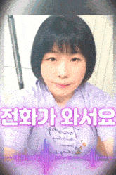 a girl in a purple shirt with korean writing on the bottom