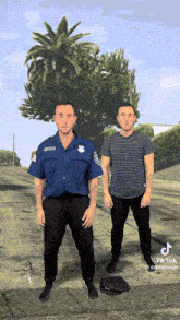 two security guards are standing next to each other in front of a palm tree and a tree in the background