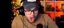 a man wearing glasses and headphones is making a funny face while talking into a microphone .