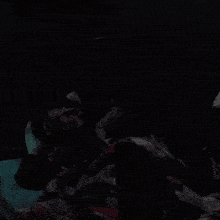 a person is laying in a dark room with a blanket on their head .