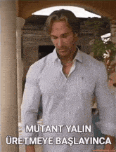 a man in a striped shirt is standing in front of a door and says mutant yaln uretmeye başlayinca