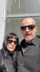 a man and a woman wearing sunglasses pose for a photo