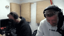 two men wearing headphones one of whom is wearing a hoodie that says kirk