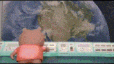 a teddy bear is standing in front of a screen with the earth in the background