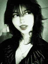 a black and white photo of a woman wearing a necklace with a cross