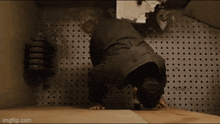 a man is crawling on the floor in a room with a tile floor