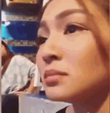 a close up of a woman 's face while sitting in a crowd .