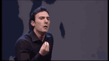 a man in a black shirt is making a funny face and the word pancetta is on the screen behind him