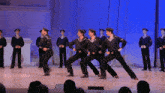 a group of men in sailor uniforms are dancing on stage