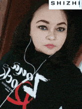 a woman wearing headphones and a shirt that says shizhi on it