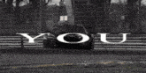 a black and white photo of a race car with the word you written on it