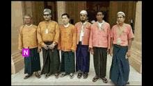 a group of men standing next to each other with the letter n on the bottom left