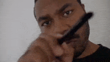 a man with a beard is holding a comb in his hand and looking at the camera .