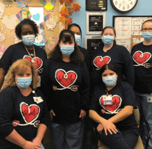 a group of nurses wearing face masks and shirts with hearts on them are posing for a photo