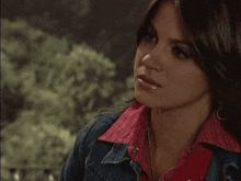 two women are looking at each other and one is wearing a red shirt
