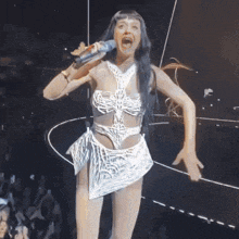 a woman singing into a microphone with her mouth wide open