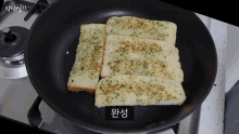 slices of garlic bread are being cooked in a frying pan on a stove top