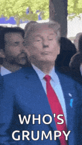 a man in a suit and tie is standing in front of a crowd .