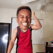 a man in a red tank top is making a face