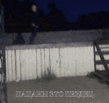 a blurry picture of a person jumping over a wooden fence with the words " пацаны это пиздец " below it