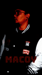 a man wearing a varsity jacket with the number 96 on the front