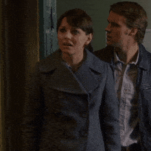 a man and a woman are standing next to each other in a doorway