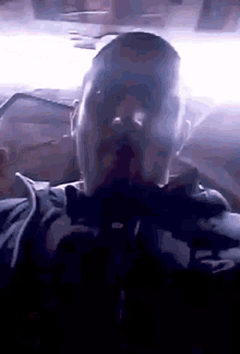 a man with a beard is taking a selfie in a dark room