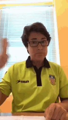 a woman wearing glasses and a yellow shirt with the word rasen on the front