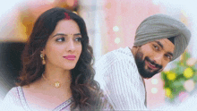 a man wearing a turban looks at a woman