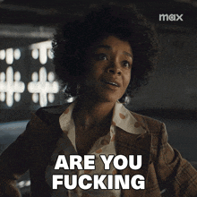 a woman says " are you fucking " while wearing a plaid suit