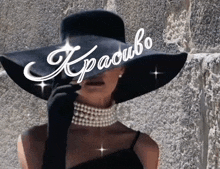 a woman wearing a black hat and a pearl necklace is covering her face with a sign that says kraoubo