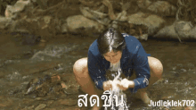 a man washing his face in a stream with judleklek702 written on the bottom right