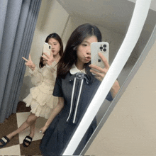 two girls are taking a selfie in front of a mirror with one wearing a dress that says miu
