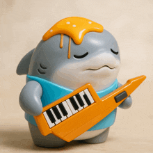 a figurine of a shark holding a keyboard