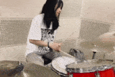a woman playing a drum set with a shirt that says ' a ' on it