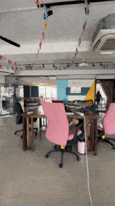 a pink office chair sits in a very large room