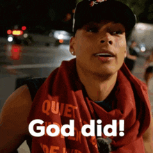 a man wearing a red scarf and a hat says god did
