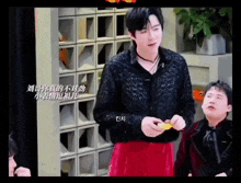 a man in a black lace shirt is standing next to another man in a red skirt ..