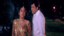 a man and a woman standing next to each other in a dark room