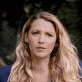 a close up of a woman 's face with long blonde hair and blue eyes