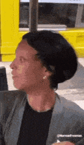 a woman is sitting in front of a yellow building .